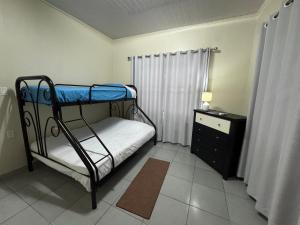 a small bedroom with a bunk bed and a dresser at Solace Sranan, Modern 2Bedroom Apartment with Garden View near Paramaribo in Wanica