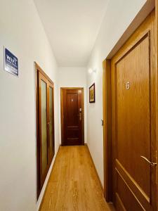 マドリードにあるRooms in Madridの二つのドアと木製の床の廊下
