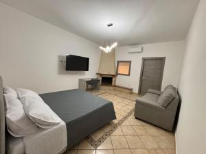 a bedroom with a bed and a couch and a tv at IL moro in Acireale