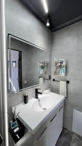 une salle de bain avec un lavabo blanc et un miroir dans l'établissement Tiny Stay, à Karakol