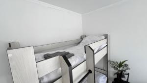 Ce lit superposé blanc se trouve dans une chambre blanche. dans l'établissement Tiny Stay, à Karakol