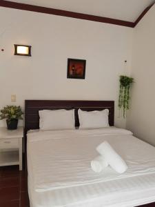 富国Tim Hotel的卧室里有一张白色的床，上面有两个枕头