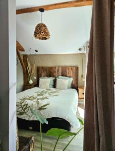 a bedroom with a large bed with a wooden headboard at Villa Rustique Le Carriou in Léon +15 photos