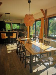 a dining room with a wooden table and chairs at Villa Rustique Le Carriou in Léon