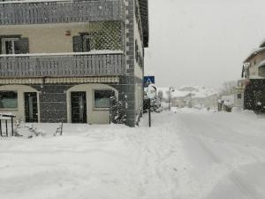 a street covered in snow next to a building at Apartments Giovannini in Fai della Paganella