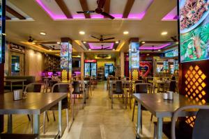a restaurant with tables and chairs and purple lights at Castle By the Sea in Calangute