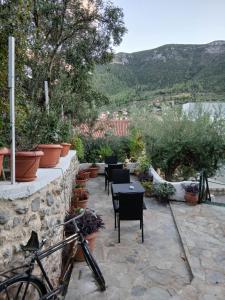 a bike parked next to a stone wall with tables and chairs at Stylianos House 6 in Leonidion