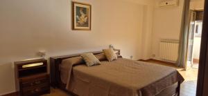 1 dormitorio con 1 cama con tocador y una foto en la pared en Casa Travaglianti - Letojanni Taormina, en Letojanni