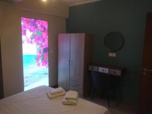 a bedroom with a bed with a mirror and a window at Stylianos House 6 in Leonidion