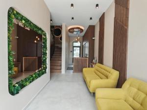a living room with two yellow couches and a green wall at POOL RESORT- Vila Lena- Apartman 2 in Vrdnik