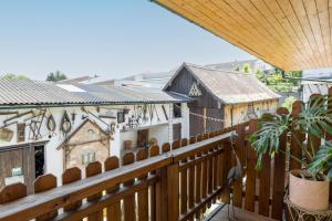 a balcony with a wooden railing and buildings at Weingut zur Schlafmütze in Herrnbaumgarten