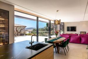 a kitchen and living room with a purple couch at VILLAS COSETTTE Villa VICENC in Platja  d'Aro