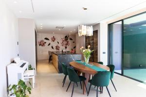 a dining room with a wooden table and green chairs at VILLAS COSETTTE Villa VICENC in Platja  d'Aro