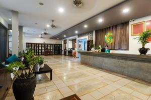 a lobby of a hotel with a woman sitting at a counter at Green Amazon Residence in Siem Reap