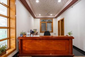 un ufficio con una scrivania di legno in una stanza con finestre di Tea Pavilion a Bangalore