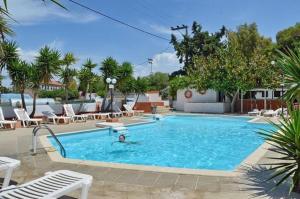 a person swimming in a large swimming pool at Miranta Hotel - Apartments & Studios in Aegina Town