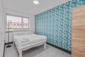 une chambre avec un lit avec un mur bleu dans l'établissement Sheaf 2 Sheldon 2BR Stay Sleeps 4 & Superfast Wi-Fi, à Sheldon