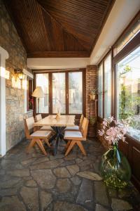 a patio with a table and chairs and windows at Elia Guesthouse Chaidemeni in Tríkala
