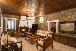 a living room with a stone wall with a fireplace at Elia Guesthouse Chaidemeni in Tríkala