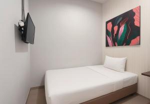 a bedroom with a white bed and a tv at Anders Arjuna Selatan in Jakarta