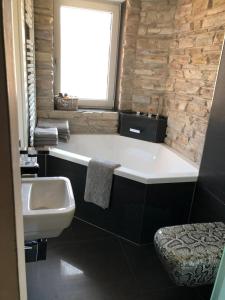 a bathroom with a bath tub and a sink at Cocktailpedia - Apartment mit Loggia in Wesel +13 photos
