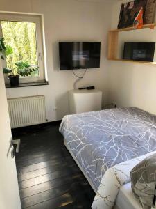 a bedroom with a bed and a flat screen tv at Cocktailpedia - Apartment mit Loggia in Wesel