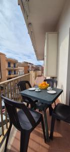 una mesa negra y sillas en el balcón en Casa Travaglianti - Letojanni Taormina, en Letojanni