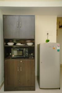 een keuken met een magnetron en een koelkast bij Sukoon by Second Homes in Candolim