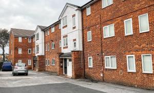 une voiture garée devant un bâtiment en briques dans l'établissement Manchester Stays Walkden, à Worsley