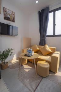 a living room with a couch and a table at The Little Home - Hoàng Hoa Thám - Cosy apartment - Center Hanoi in Hanoi