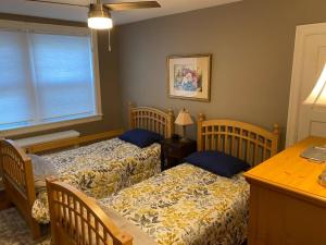 a bedroom with two beds and a table and a desk at Bryn Mawr Spacious Grnd Floor Apt Free Parking in Bryn Mawr