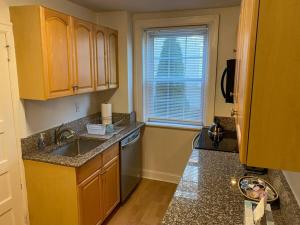a kitchen with wooden cabinets and a sink and a window at Bryn Mawr Spacious Grnd Floor Apt Free Parking in Bryn Mawr +7 photos