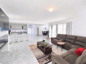 a living room with a couch and a table at Greenview Haven in Stompneusbaai