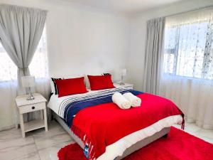 a bedroom with a large bed with red pillows at Greenview Haven in Stompneusbaai