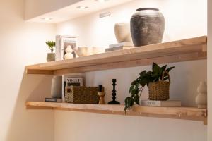 NiederdorlaにあるMit Terrasse und Blick ins Grüneの花瓶と植物が置かれた棚