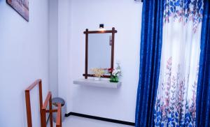 a room with a mirror and a blue curtain at Mountain Breeze Villa in Ella +43 photos