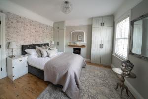 a bedroom with a large bed and a fireplace at Seaside 5-Bed Coastal Getaway in Exmouth