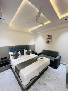 ein Schlafzimmer mit einem großen Bett und einer Couch in der Unterkunft Hotel Pacific Inn in Ahmedabad