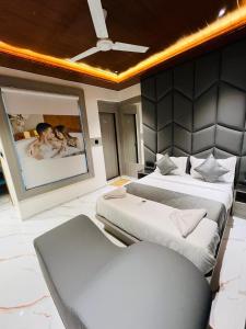 Großes Zimmer mit 2 Betten und einem Sofa in der Unterkunft Hotel Pacific Inn in Ahmedabad + 7 Fotos