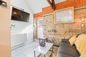 a living room with a couch and a table at The Old Wash House - North East Escapes in Amble