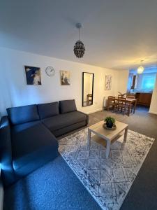 a living room with a blue couch and a table at 2 Bed - Sleeps 6 - Free Parking in Bracknell