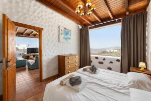 a bedroom with a bed and a large window at Finca Morro Herreno in Las Breñas