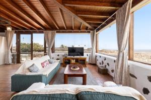 a living room with a couch and a tv at Finca Morro Herreno in Las Breñas