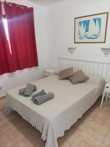 a bedroom with a bed with two pillows on it at Dunasol Fuerteventura in Corralejo