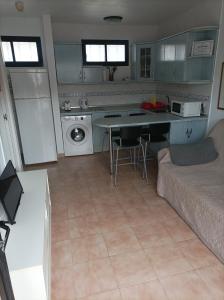 a kitchen with a couch and a table in a room at Dunasol Fuerteventura in Corralejo