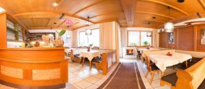 a restaurant with wooden ceilings and tables and chairs at Hotel Christoph in Neustift im Stubaital