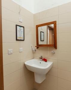 a bathroom with a white sink and a mirror at Smile Homes in Zanzibar City