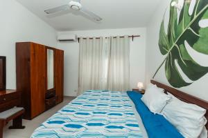 a bedroom with a bed and a painting on the wall at Smile Homes in Zanzibar City