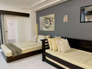 ein Schlafzimmer mit zwei Betten und einem Gemälde an der Wand in der Unterkunft City Land Tagaytay Prime in Ulot