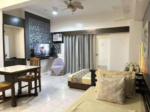 ein Schlafzimmer mit einem Bett, einem Schreibtisch und einem Tisch in der Unterkunft City Land Tagaytay Prime in Ulot